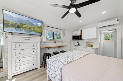 1 dormitorio blanco con 1 cama y TV de pantalla plana en Magic Mountain 4 Bedroom 3 Bath Escape Modern Home, en Santa Clarita