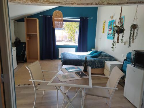 a living room with a table and a bed at CAP MANVIEUX Gîtes in Manvieux