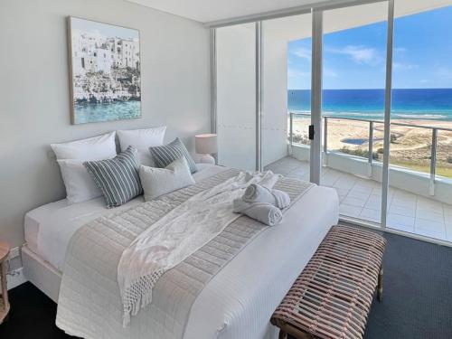 a bedroom with a large bed with a view of the ocean at Kirra Penthouse with Private Spa in Gold Coast