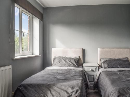 a bedroom with two beds and a window at Meadow Walk in Sudbury