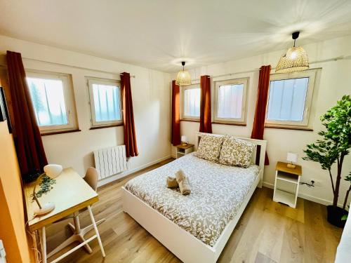 - une petite chambre avec un lit et des fenêtres dans l'établissement Orangeraie, à Rouen