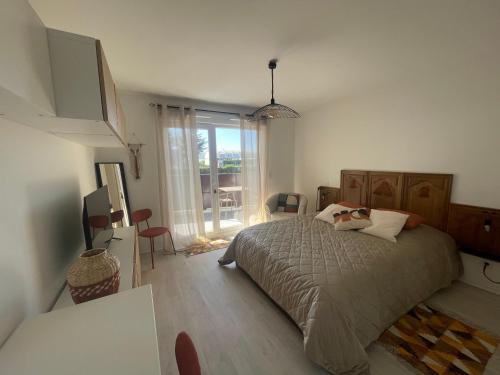 une chambre avec un lit et une grande fenêtre dans l'établissement Studio 115 Wellness Cap d'Agde, au Cap d'Agde