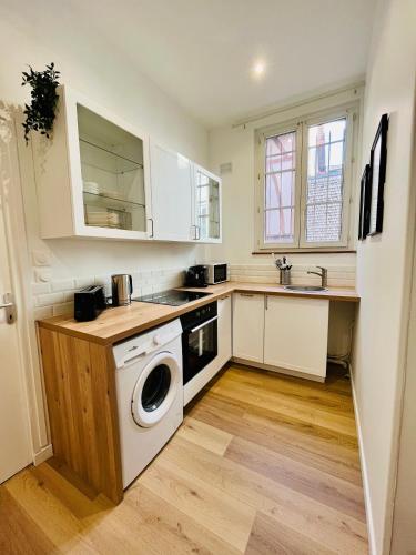 une cuisine avec une machine à laver et un évier dans l'établissement Orangeraie, à Rouen