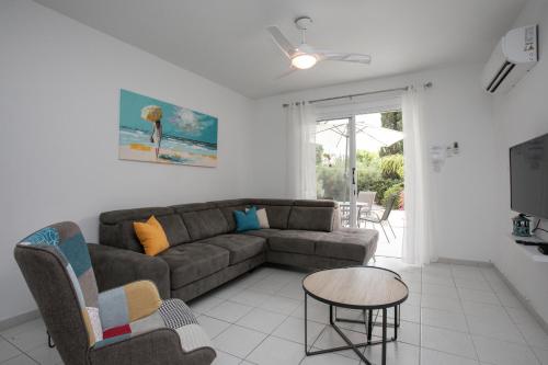 a living room with a couch and a table at Casa Del Sol Townhouse in Iris Village Paphos in Paphos City