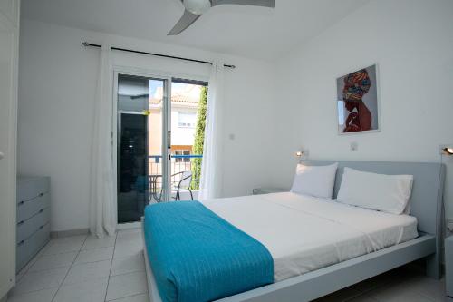 1 dormitorio con 1 cama con manta azul en Casa Del Sol Townhouse in Iris Village Paphos en Pafos