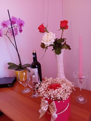a table with flowers in vases and wine glasses at Casa Dănuț in Reşiţa