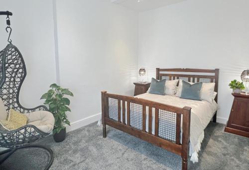 a bedroom with a bed and a chair and a plant at Perfectly located City Centre apartments in Exeter