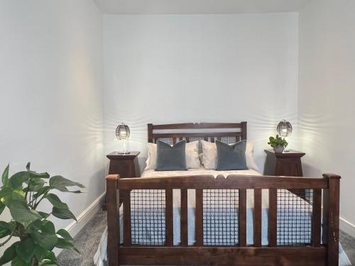 a bedroom with a wooden bed with two night stands at Perfectly located City Centre apartments in Exeter