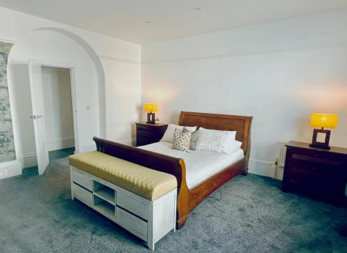 a bedroom with a bed and a stool and two lamps at Perfectly located City Centre apartments in Exeter