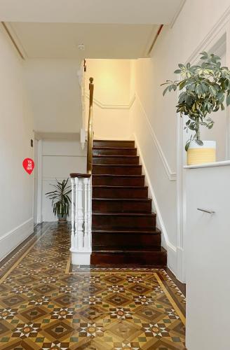 a hallway with a staircase with a mosaic floor at Perfectly located City Centre apartments in Exeter