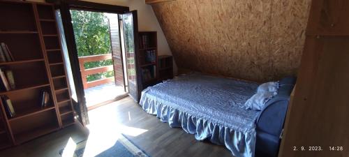 a bedroom with a bed and a sliding glass door at Vikendica Popovic in Doboj