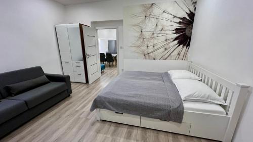 1 dormitorio con 1 cama y 1 sofá en Ella Appartement, en Mariánské Lázně