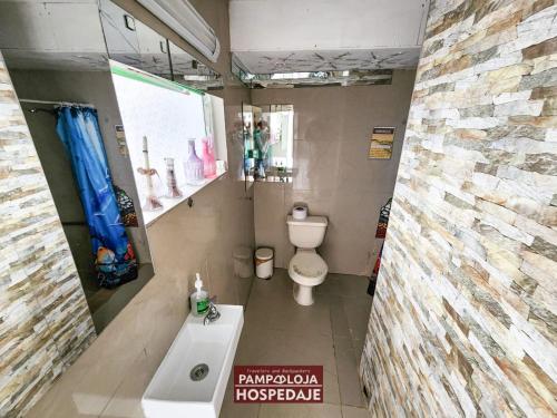 a bathroom with a toilet and a sink at Hostal Pampaloja Antof in Antofagasta