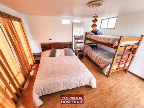 a bedroom with two beds and a bunk bed at Hostal Pampaloja Antof in Antofagasta