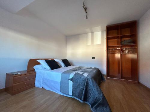 1 dormitorio con 1 cama y armario de madera en Casa Grabo en Cors