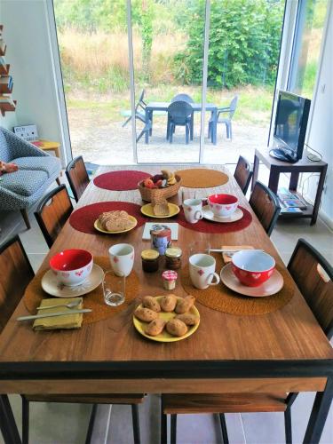 ein Holztisch mit Tellern voller Essen darauf in der Unterkunft Chez Clo & Tonio in Saint-Hélen