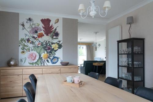 布拉克爾的住宿－Vakantiewoning Hoge Zavel，餐桌,墙上挂着一幅花画