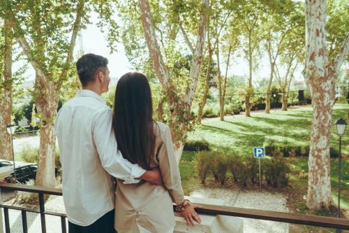 a man and a woman standing next to a fence at Estalagem Santa Iria Hotel & Spa in Tomar