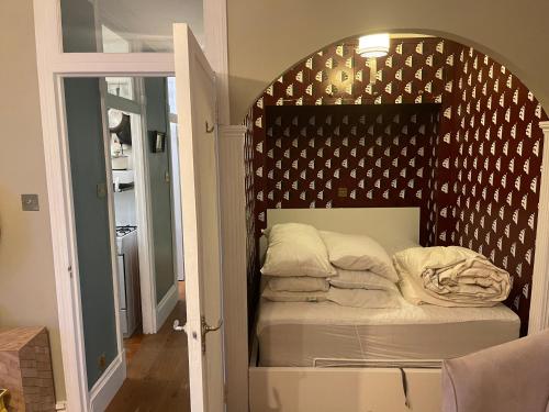 Habitación con cama en una habitación con pared en Chelsea Manor Studio, en Londres