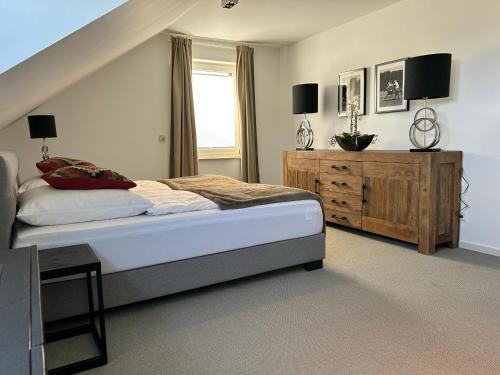 1 dormitorio con cama y tocador de madera en Romantikchalet Neuastenberg/Winterberg, en Winterberg