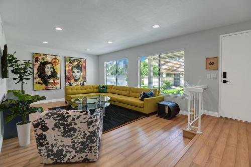 ein Wohnzimmer mit einem gelben Sofa und einem Tisch in der Unterkunft Two Chic at Mountain Shadows in Palm Springs