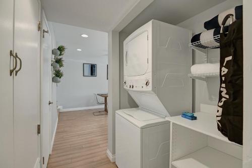 a white laundry room with a washer and dryer at Two Chic at Mountain Shadows in Palm Springs