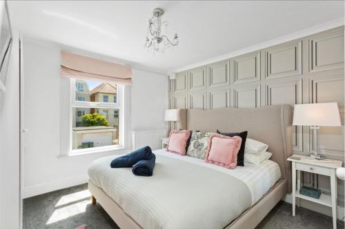 a bedroom with a bed with pink pillows and a window at Ahoy There! in Hythe
