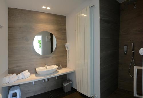 La salle de bains est pourvue d'un lavabo et d'un miroir. dans l'établissement Ca del Lac Rooms, à Castro