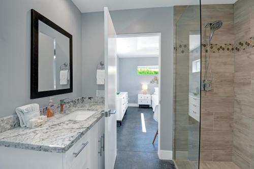 ein Bad mit einer Dusche, einem Waschbecken und einem Spiegel in der Unterkunft Deja Blue in Palm Springs