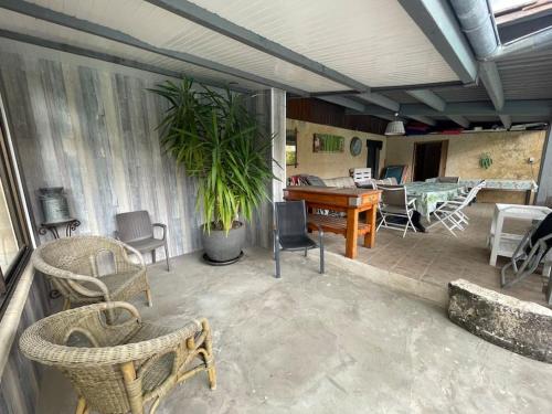 a patio with a table and chairs and a desk at Gite de charme en pierres apparentes : Les Granges in Gardonne