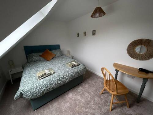 1 dormitorio con 1 cama, 1 mesa y 1 silla en 3 - Rabbit Warren, Bright décor home & private hot tub, en Norwich