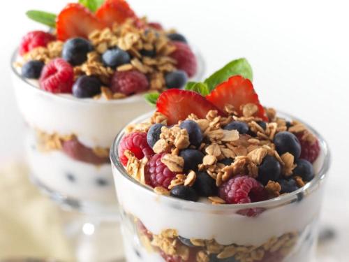 two cups of yogurt with berries and granola at Eleni Rooms in Parikia