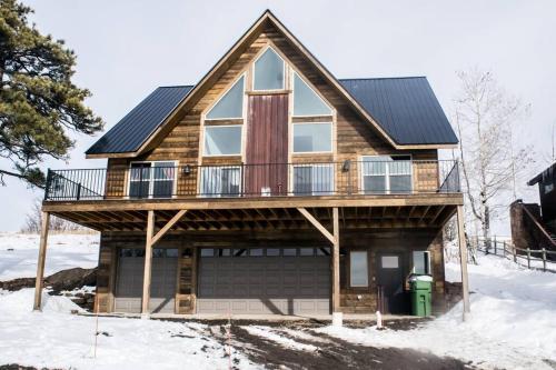 a house with a deck on top of snow at The “Worst” Home, Best Stay In Pagosa Springs in Pagosa Springs