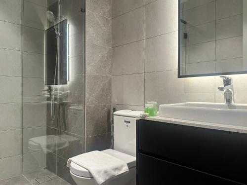 吉隆坡的住宿－Axon Luxury Suites KL，浴室配有卫生间、盥洗盆和淋浴。