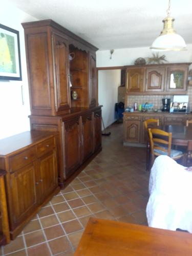 une grande cuisine avec des placards en bois et une table dans l'établissement L'appartement, à Audresselles