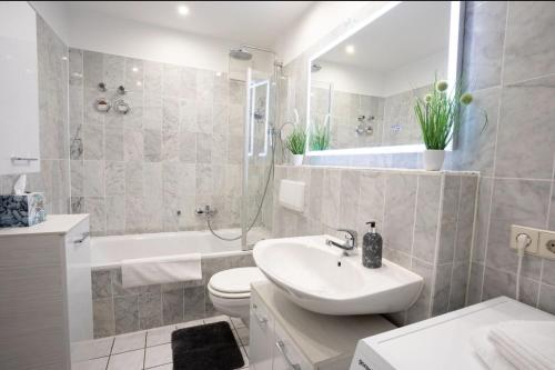 a bathroom with a sink and a toilet and a tub at Ottostadt in Magdeburg