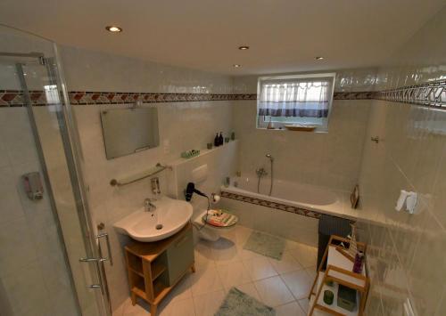 ein Badezimmer mit Badewanne, Waschbecken und Dusche in der Unterkunft Ferienhaus am Bach Koblenz in Koblenz