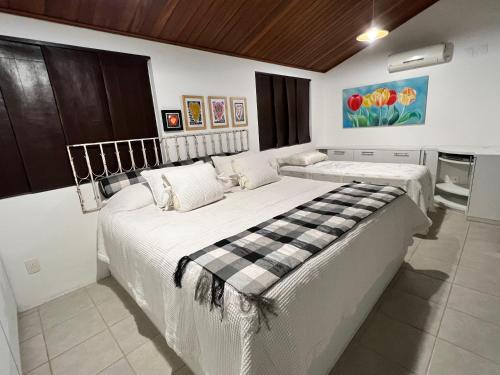 2 Betten in einem weißen Zimmer mit in der Unterkunft Flat 414 Condominio Villa Hípica - Gravatá PE in Gravatá
