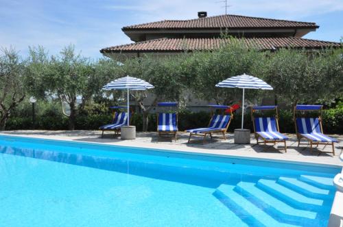 a group of chairs and umbrellas next to a swimming pool at B&B Titty in Montottone