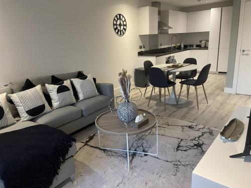 a living room with a couch and a table at Luxury Spring Stays Lichfield City Centre 2 Bedroom Apartment With Free Secure Parking in Lichfield