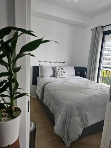 a bedroom with a bed and a potted plant at Flat Maravilhoso - Metrô - USP - Butantã in Sao Paulo