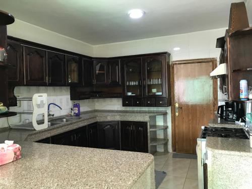 a kitchen with wooden cabinets and a counter top at Euphoria bed & breakfast in Wadi Musa