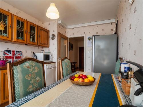 une cuisine avec une table avec un bol de fruits dessus dans l'établissement Appartement entier 2 chambres Strasbourg-Lingolsheim, proche de tram, à Lingolsheim