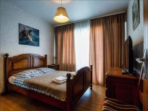 une chambre avec un lit, une télévision et une fenêtre dans l'établissement Appartement entier 2 chambres Strasbourg-Lingolsheim, proche de tram, à Lingolsheim