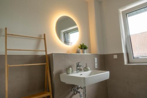 a bathroom with a sink and a mirror at HAMA Design Homes Paderborn 4 Apartments in Paderborn