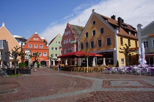 a city street with chairs and tables and buildings at FairSleep Motel Einstein Erding in Erding