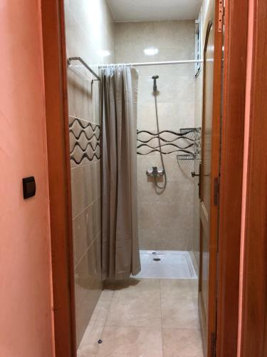 a bathroom with a shower with a shower curtain at Luxurious Family Holiday Home in Temara