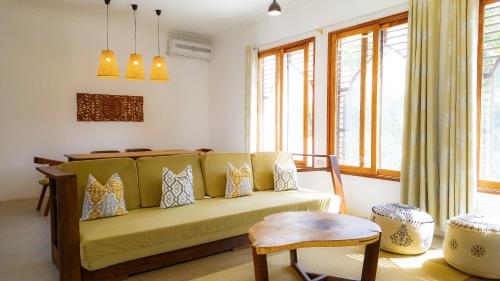 uma sala de estar com um sofá amarelo e uma mesa em The Cliff 2 Bedroom Beach Apartment em Mazizini