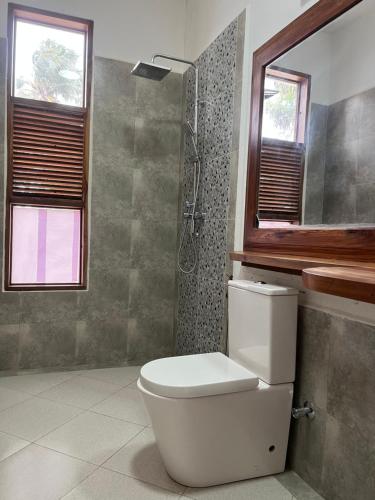 een badkamer met een toilet en een douche bij The Cliff 2 Bedroom Beach Apartment in Mazizini