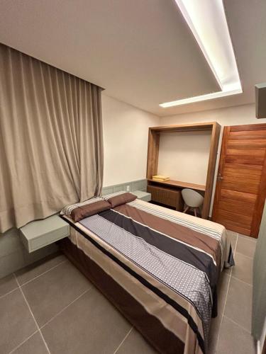 a hotel room with a bed and a window at Chaleville barrinha in Barrinha